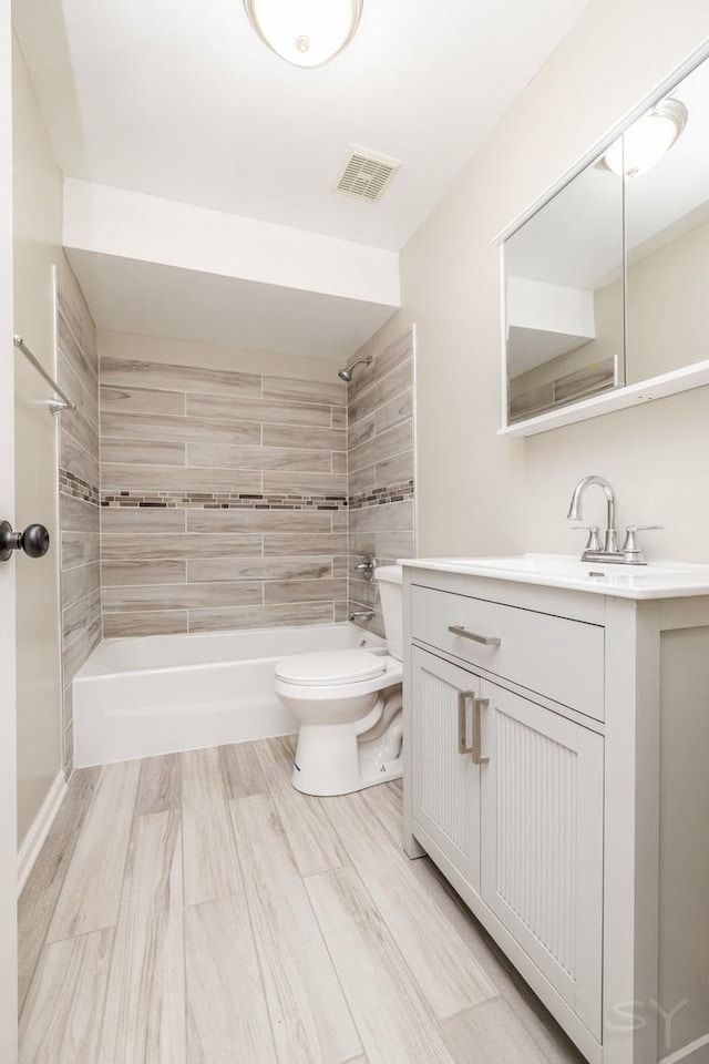 bathroom with visible vents, vanity, toilet, and shower / tub combination