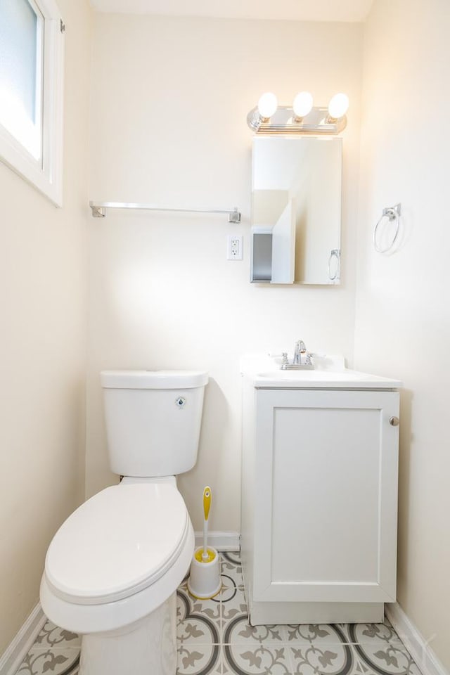 bathroom featuring vanity, toilet, and baseboards