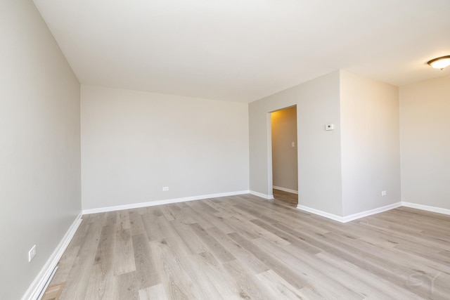 unfurnished room featuring baseboards and light wood-style floors