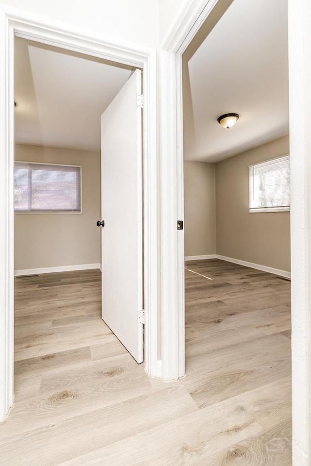 hallway with baseboards and wood finished floors