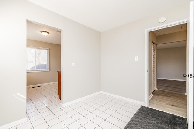 unfurnished room with light tile patterned flooring and baseboards