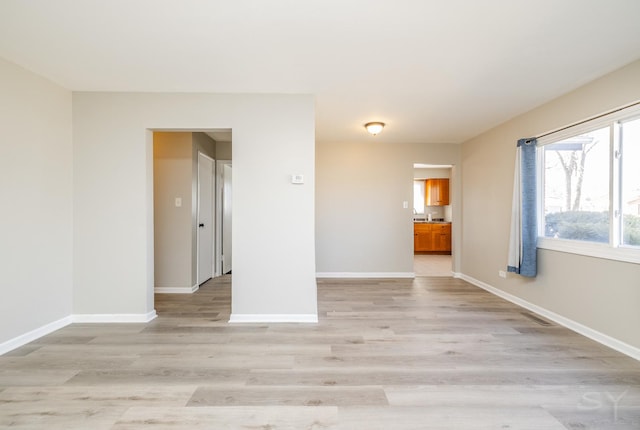 spare room with light wood-style floors and baseboards