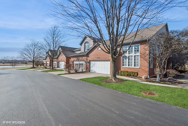 view of front of house with concrete driveway, an attached garage, and brick siding