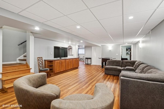 living room featuring stairway, recessed lighting, a paneled ceiling, and light wood-type flooring