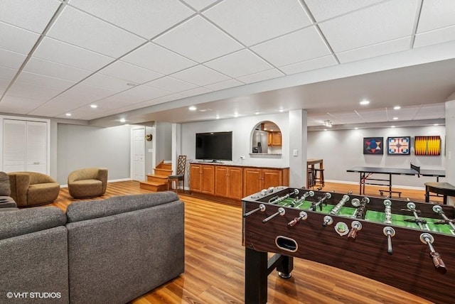 playroom with recessed lighting, baseboards, a paneled ceiling, and light wood-style floors