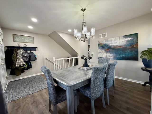 dining space featuring wood finished floors, visible vents, a chandelier, and baseboards