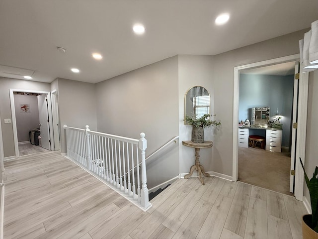 corridor featuring recessed lighting, an upstairs landing, light wood-type flooring, and baseboards