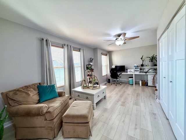 home office with a ceiling fan and light wood-style floors