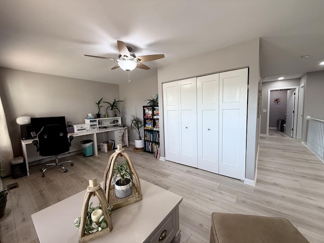 home office with light wood-style floors, baseboards, and ceiling fan