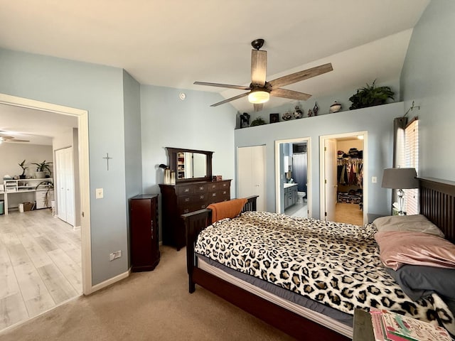 bedroom with a walk in closet, vaulted ceiling, ensuite bathroom, a closet, and a ceiling fan