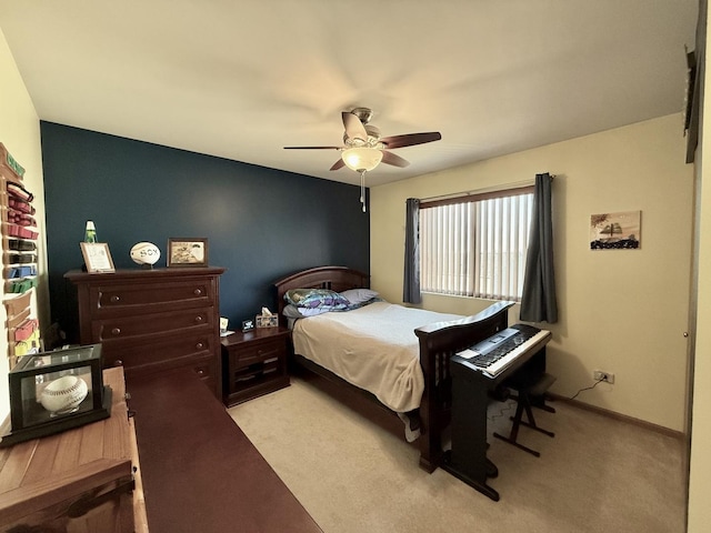 bedroom featuring light colored carpet, baseboards, and a ceiling fan