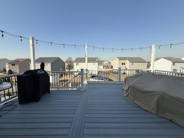 wooden terrace with a residential view and grilling area