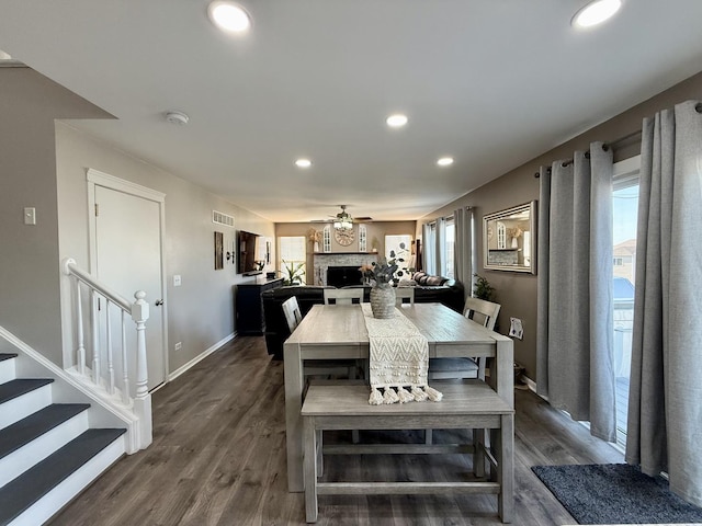 dining area with dark wood finished floors, a healthy amount of sunlight, and a fireplace