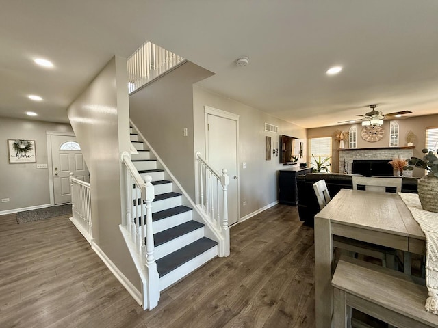 dining area featuring dark wood-type flooring, recessed lighting, stairway, a fireplace, and baseboards