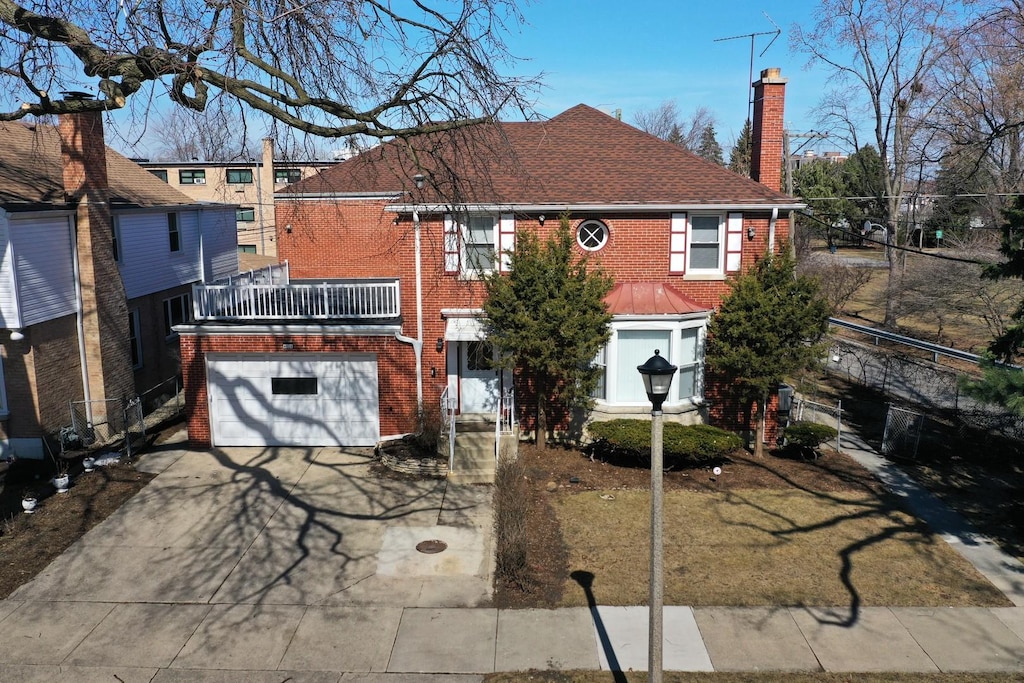 4820 Hull St, Skokie, IL 60077 - view of front of home featuring roof with shingles, driveway, a chimney, a garage, and brick siding
