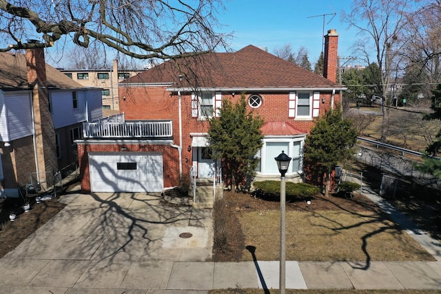 view of front of home with brick siding, concrete driveway, roof with shingles, a chimney, and an attached garage