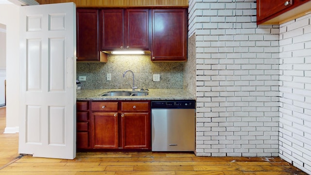 kitchen with dishwasher, reddish brown cabinets, and a sink