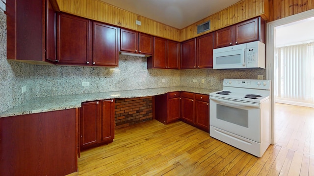 kitchen featuring visible vents, white appliances, light wood-style floors, reddish brown cabinets, and light stone countertops