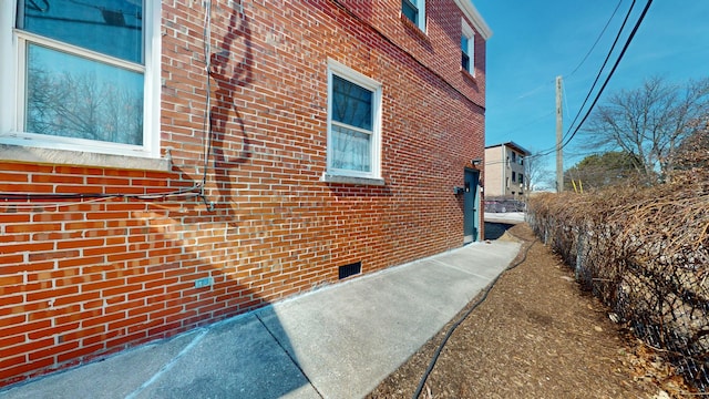 view of property exterior with brick siding and crawl space