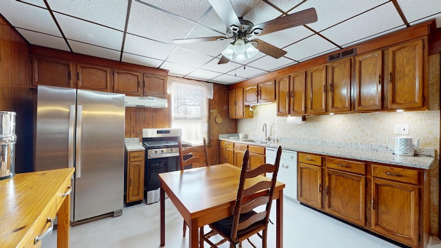 kitchen with visible vents, a sink, under cabinet range hood, appliances with stainless steel finishes, and backsplash