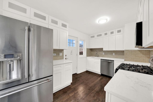 kitchen featuring glass insert cabinets, dark wood-type flooring, tasteful backsplash, and appliances with stainless steel finishes