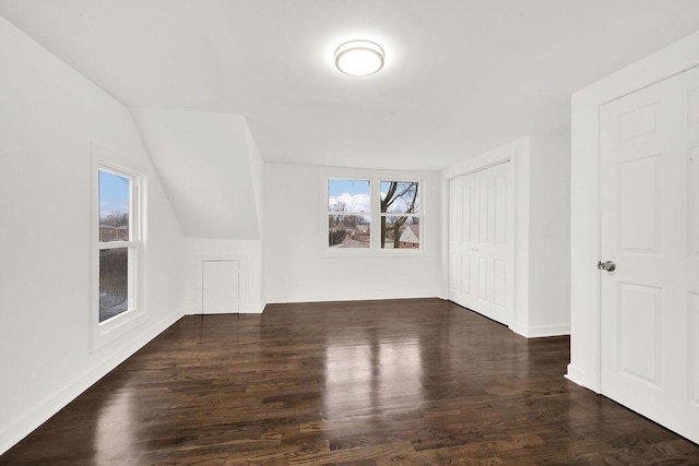 bonus room with baseboards, lofted ceiling, and wood finished floors