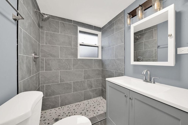 full bath with tiled shower, toilet, and vanity