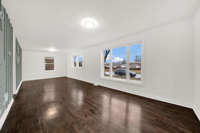 unfurnished room with dark wood-style floors and baseboards