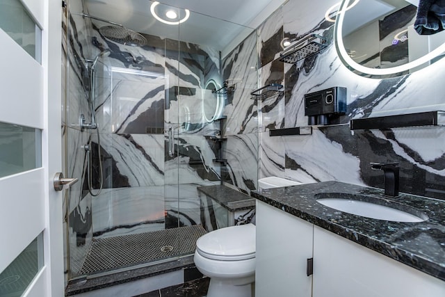 bathroom with vanity, a marble finish shower, tile walls, toilet, and marble finish floor