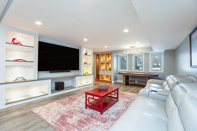 living room featuring recessed lighting, baseboards, built in shelves, and wood finished floors