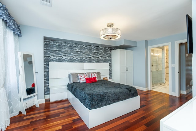 bedroom featuring visible vents, baseboards, and wood finished floors