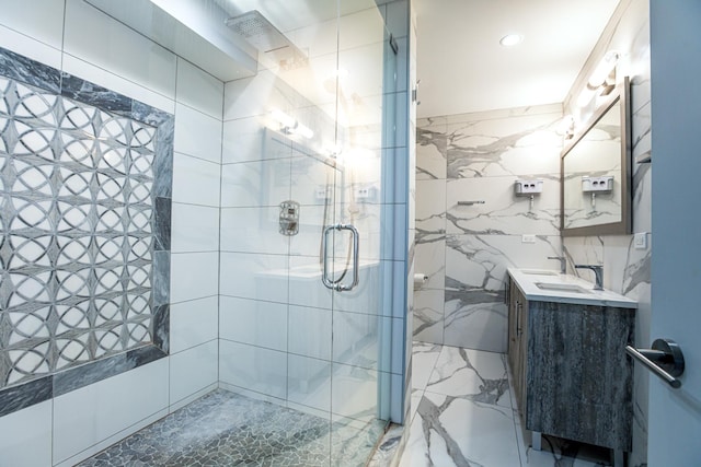 full bath with tile walls, a stall shower, and vanity