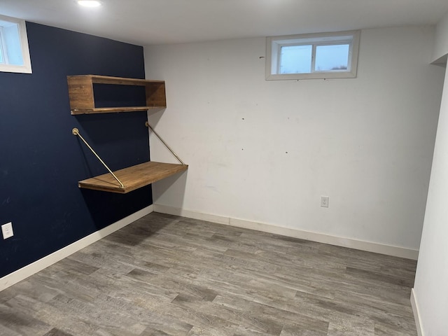 basement featuring baseboards and wood finished floors