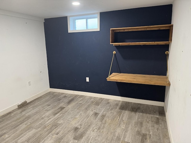 below grade area featuring wood finished floors and baseboards