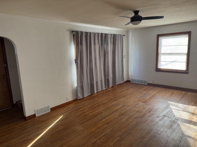 unfurnished room featuring arched walkways, visible vents, a ceiling fan, and ornamental molding