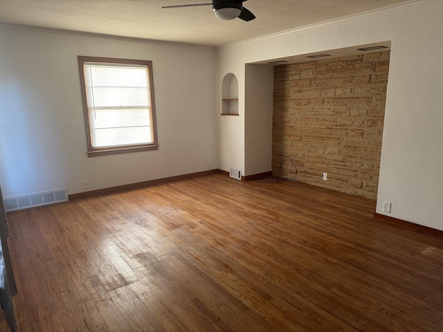 unfurnished bedroom featuring visible vents, ornamental molding, and wood finished floors