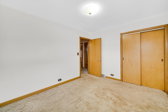 unfurnished bedroom with visible vents, carpet, baseboards, and a closet