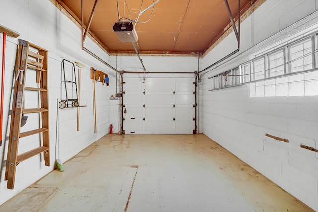 garage featuring a garage door opener and concrete block wall