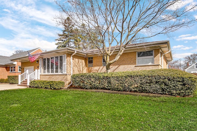 view of front of home featuring driveway, brick siding, a front yard, and a sunroom