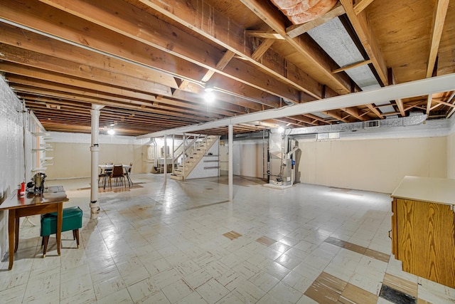 unfinished basement with stairs, tile patterned floors, and heating unit