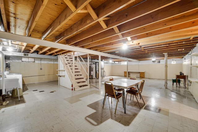 finished below grade area featuring stairway, light floors, water heater, and washing machine and dryer