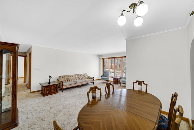 dining room featuring baseboards, carpet, ornamental molding, arched walkways, and a notable chandelier