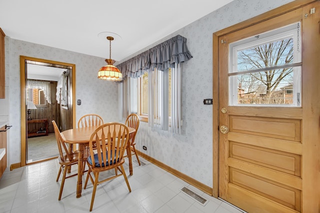 dining room featuring a wealth of natural light, visible vents, wallpapered walls, and baseboards