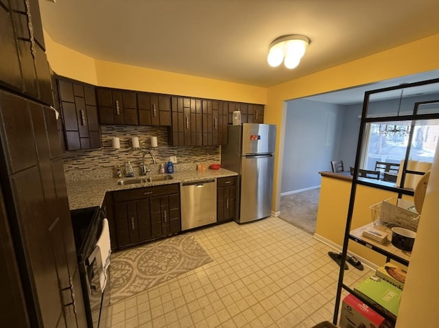 kitchen with a sink, tasteful backsplash, stainless steel appliances, dark brown cabinetry, and baseboards