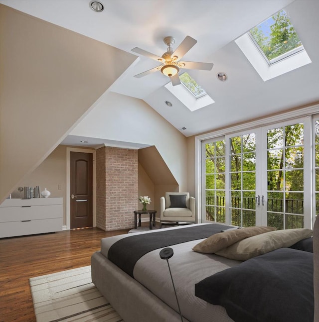 bedroom with lofted ceiling with skylight, a ceiling fan, wood finished floors, recessed lighting, and french doors