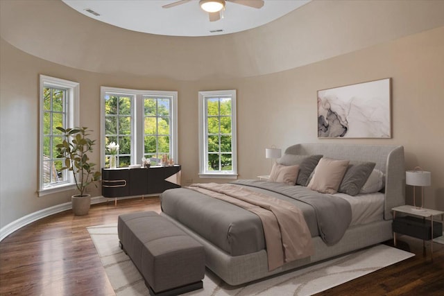 bedroom featuring ceiling fan, wood finished floors, visible vents, and baseboards