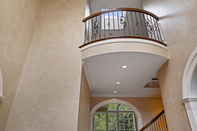 stairs featuring recessed lighting, a towering ceiling, and ornamental molding