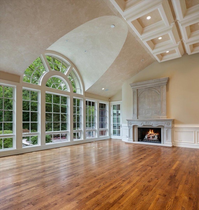 unfurnished living room featuring beamed ceiling, a premium fireplace, recessed lighting, wood-type flooring, and a decorative wall