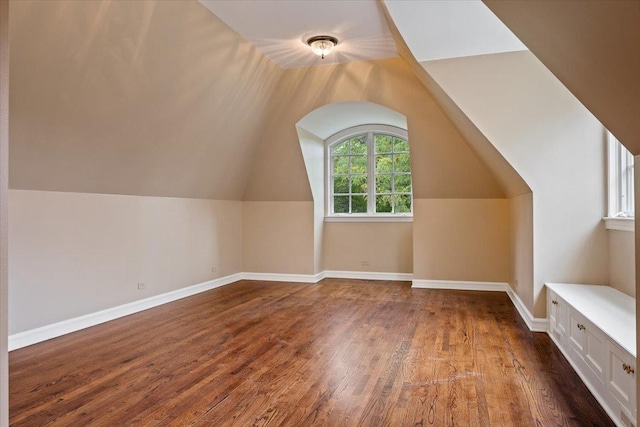 bonus room featuring baseboards, lofted ceiling, and wood finished floors