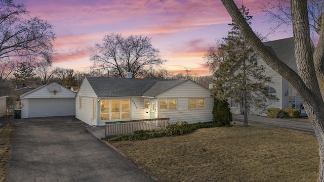 view of front of home with roof with shingles, a lawn, a chimney, a garage, and an outdoor structure